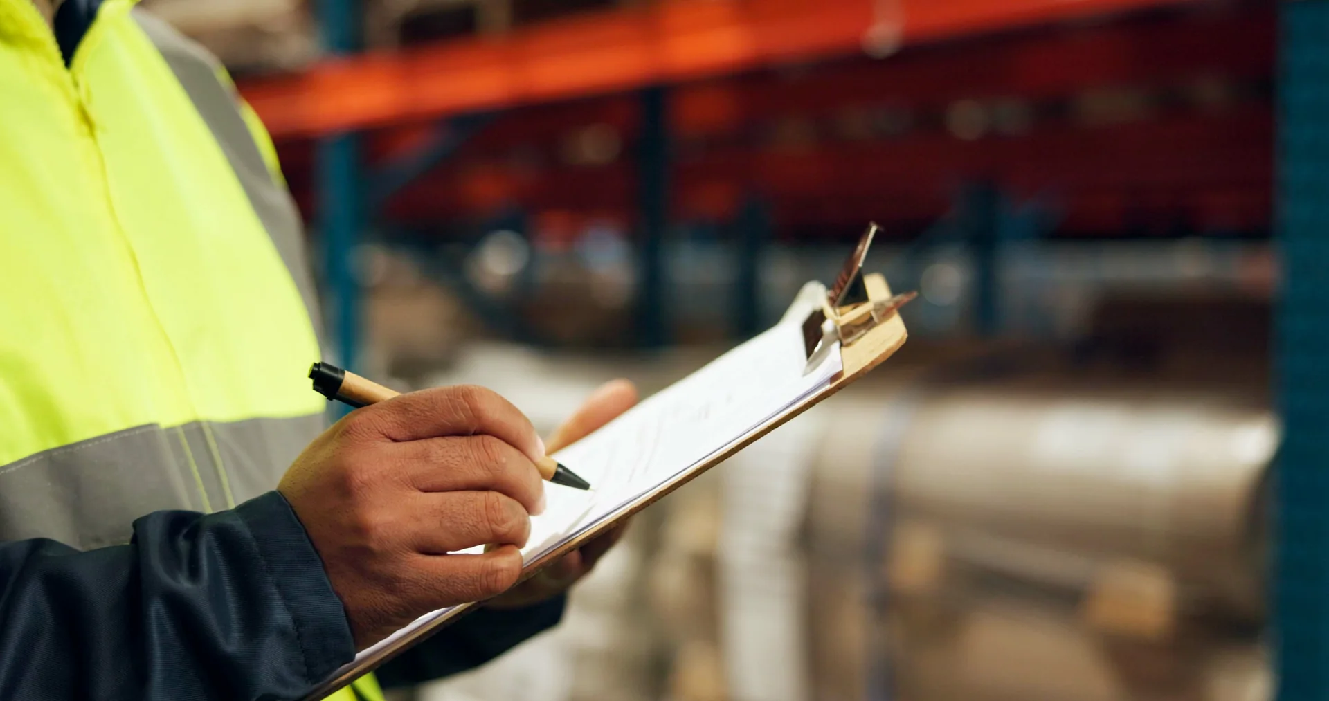 Warehouse specialist completing an equipment audit on a clipboard